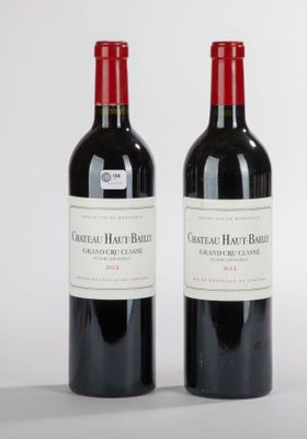 deux bouteilles de vin rouge posées l'une à côté de l'autre sur une surface blanche