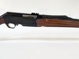 un fusil posé sur un socle en acrylique transparent, sur une surface blanche