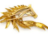 gold plated brooch with a horse head and leaves on it