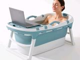 a woman sitting in a bath tub with a laptop on her lap