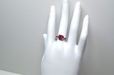 une main de mannequin blanche ornée d'une bague rouge