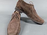 a pair of brown sued shoes sitting on top of a gray surface