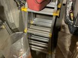 un seau rouge posé sur une échelle dans un garage