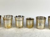 six verres à liqueur argentés alignés les uns à côté des autres