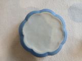 un bol bleu et blanc posé sur une nappe blanche