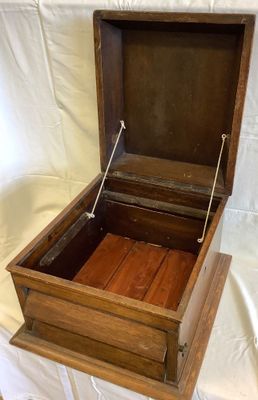 une boîte en bois ouverte posée sur un drap blanc