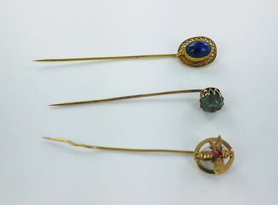 trois broches plaquées or ornées de pierres bleues et des épingles à cheveux plaquées or