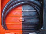a black and orange box with a black hose in it