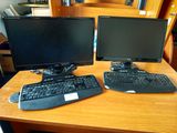 deux écrans d'ordinateur et un clavier sur un bureau