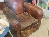 un fauteuil en cuir marron placé devant une étagère en verre