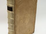 an old book sitting on top of a white table next to a white wall