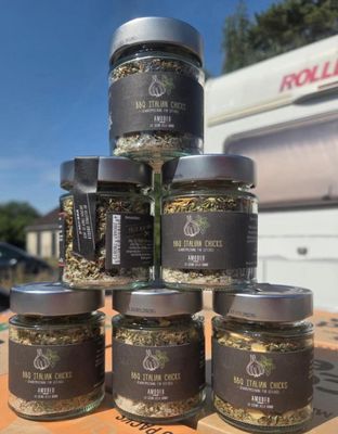 six jars of spices sit on top of a wooden table