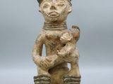 an old figurine of a man holding a baby