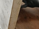 a piece of wood on the floor next to a black glove