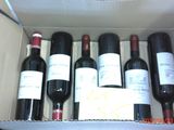 six bouteilles de vin dans un carton sur la table