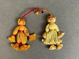 two small ornaments of a woman and a man on a broom