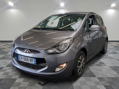 La voiture grise est garée sur le sol à damier du garage.