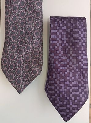 two men ' s ties hanging on a wall next to each other