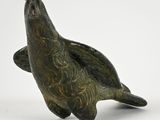 a bronze statue of a sea turtle on a white background