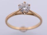 a yellow gold engagement ring with a round brilliant cut diamond