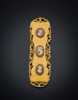 a gold broochle with two cameos of two men and a woman