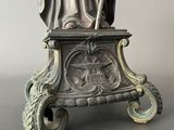 statue of a man holding a staff on a pedestal