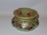 a small green box with red flowers on it