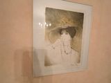 a picture of a woman in a hat hanging on a wall