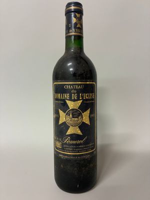 an old bottle of wine sitting on top of a white table