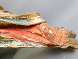 un gros plan sur une sculpture représentant un poisson posée sur une table