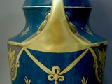 a blue and gold vase with a lid on a table