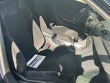 l'intérieur d'une voiture, la portière ouverte et un passager assis sur le siège passager