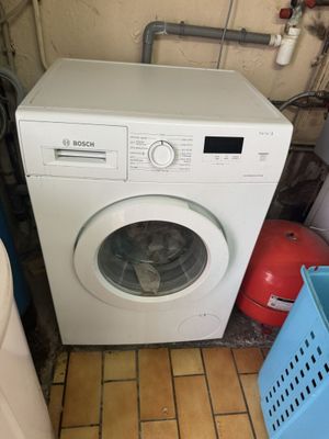 une machine à laver posée dans un coin de la pièce