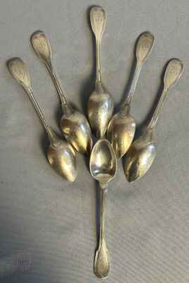 five spoons arranged in a circle on a table