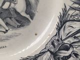 a black and white plate with a drawing of a man on a horse