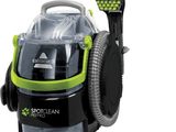 un gros plan d'un aspirateur vert et noir sur fond blanc