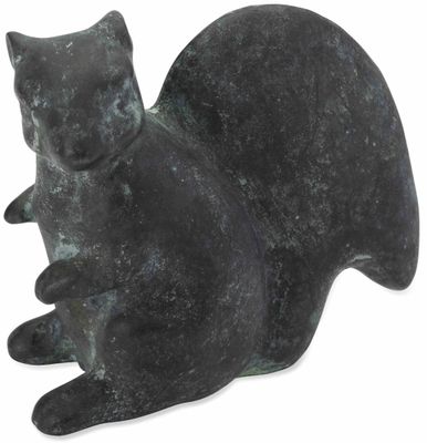 statue d'un chat assis sur ses pattes arrière sur une surface blanche
