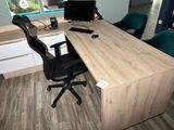 a desk with a chair and a computer on it