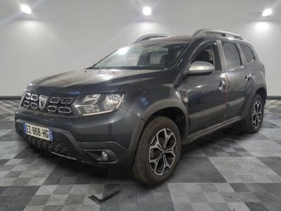 une photo d'une dacia grise garée sur un sol en damier