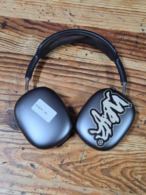 headphones on a wooden table with a black case and a white sticker on it