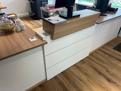 un bureau sur lequel est posé un ordinateur portable, dans un coin de la pièce