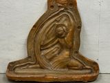 statue of a woman holding a child on a shelf in front of a white wall