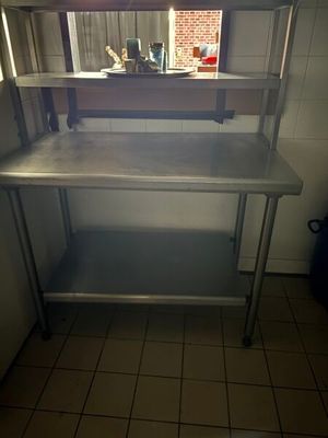 une table de travail en acier inoxydable surmontée d'un miroir