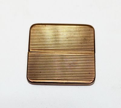 un étui à cigarettes en or ancien posé sur une table blanche
