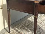 a wooden table with a drawer underneath it on a tiled floor