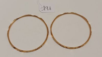 une paire de boucles d'oreilles en or sur fond blanc