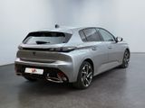 the rear end of a silver car in a white room