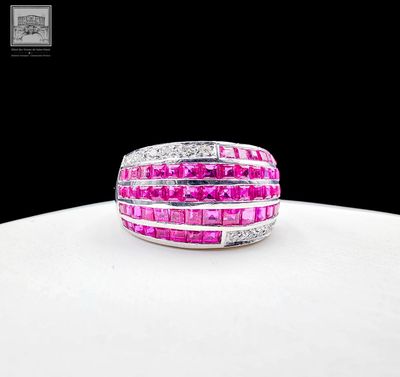 une photo d'une bague sertie d'un diamant rose et blanc posée sur une surface blanche