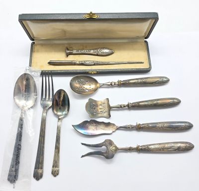 un coffret d'argenterie contenant une cuillère, une fourchette, une cuillère et un repose-cuillère