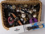 un panier rempli de montres de toutes sortes et d'autres objets